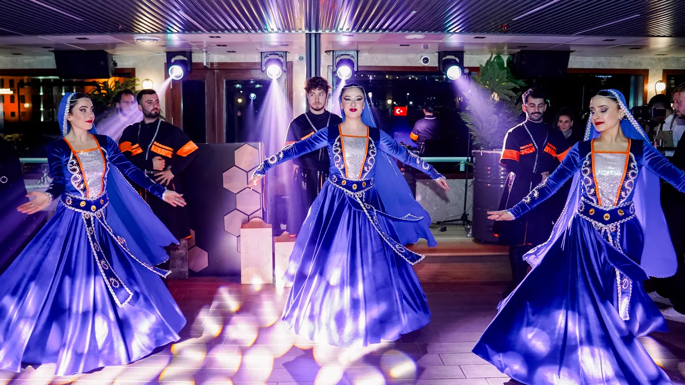 Folk dancers in traditional blue costume performing on the cruise